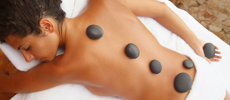 A woman enjoying hot stone therapy